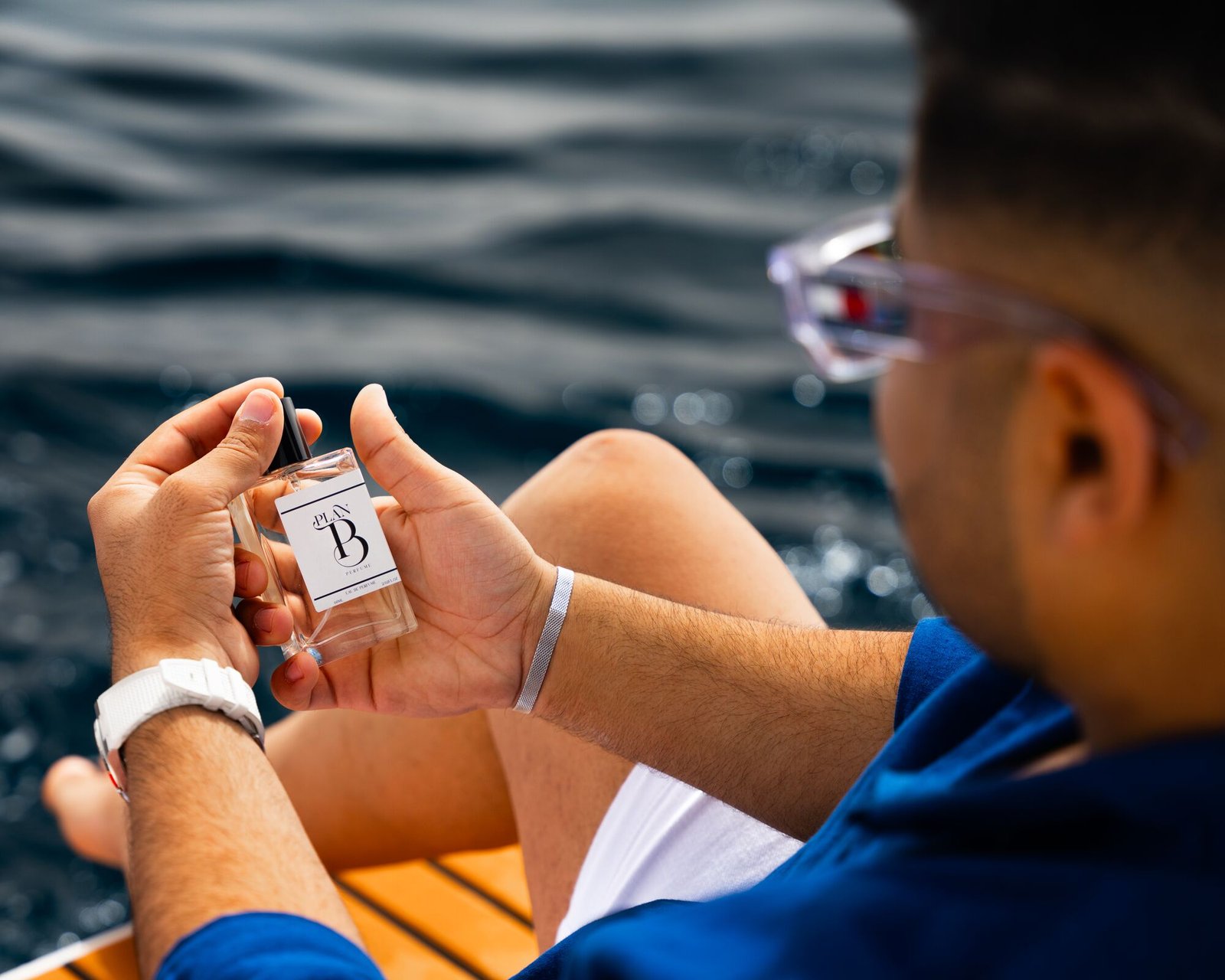Plan B perfume in hand on a yacht – lifestyle product photography
